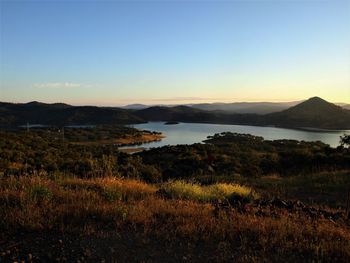 Scenic view of lake and mountains against clear sky