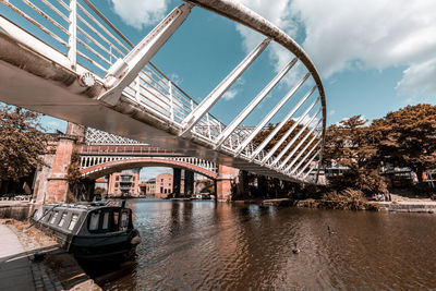 Bridge over river against sky in city