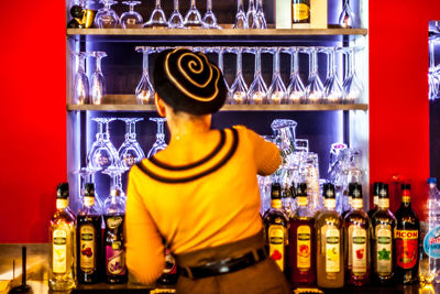 Rear view of man standing in glass bottles