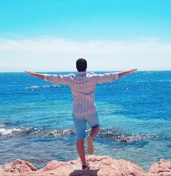 Full length rear view of man standing on beach