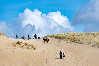 People walking on sand dune