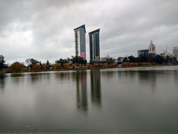 Scenic view of lake by buildings against sky