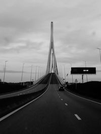 View of bridge over road against cloudy sky