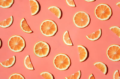 Pattern of many sliced lemons and oranges on a trendy bright pink background. flat lay, top view