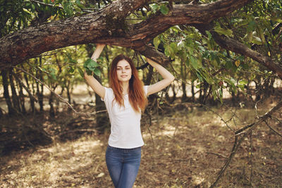 Portrait of smiling young woman standing in park