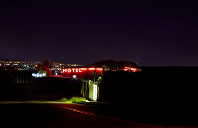 Illuminated city against clear sky at night