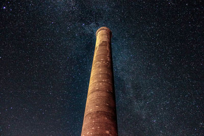 Low angle view of smoke stack against sky at night