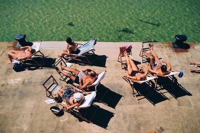 High angle view of tourist sunbathing next to swimming pool