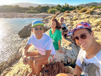 Friends sitting on rock cliff