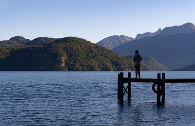 Rear view of man standing by lake