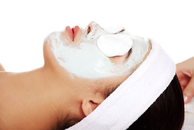 Young woman wearing face mask against white background