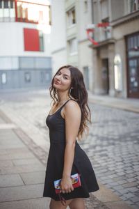 Portrait of woman standing on street in city