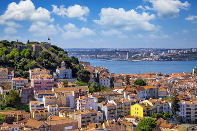 High angle view of townscape by sea against sky