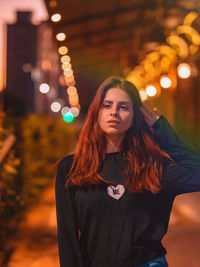 Portrait of beautiful woman standing at night