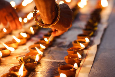 Close-up of lit candles burning in temple