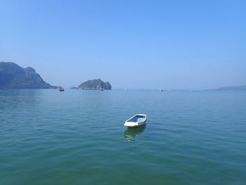 Boat sailing in sea against clear sky