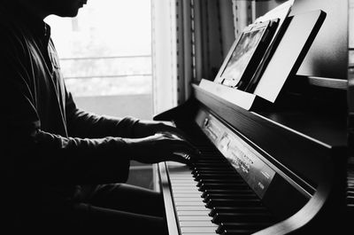 Close-up of hand playing piano