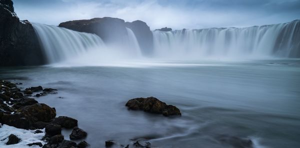 Low angle view of waterfall against sky