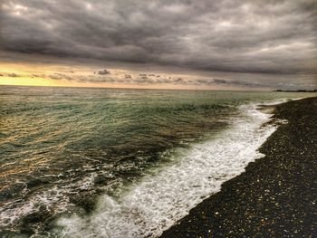 Scenic view of sea against storm clouds