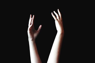 Close-up of woman hand against black background