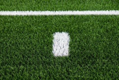 White line on green football field. artifical grass with white paint mark, soccer playfield