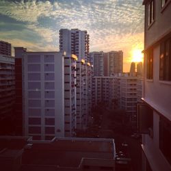 Modern cityscape against sky during sunset