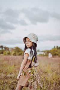 Side view of girl holding plant outdoors