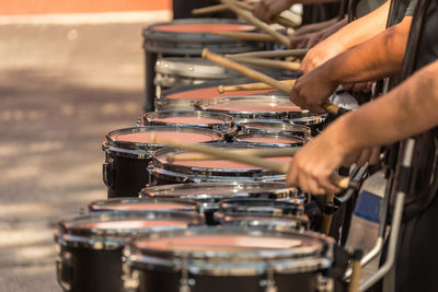 A section of a marching band drum line warming up for a parade