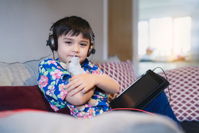 Boy sitting on sofa at home