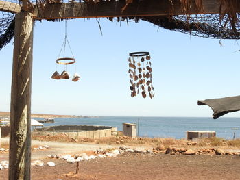 Clothes hanging on beach against clear sky