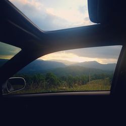 View of landscape against sky seen through car windshield