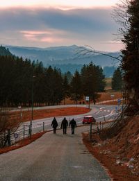 Rear view of people walking on road in winter
