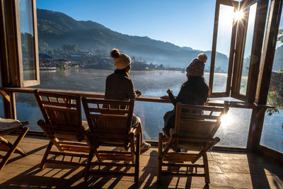 People sitting on table by mountains against sky