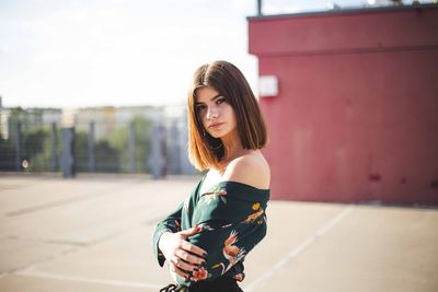 Portrait of young woman standing in city