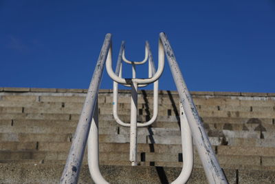 Low angle view of metallic structure against blue sky