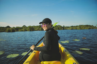 Rear view of woman kayaking in lake