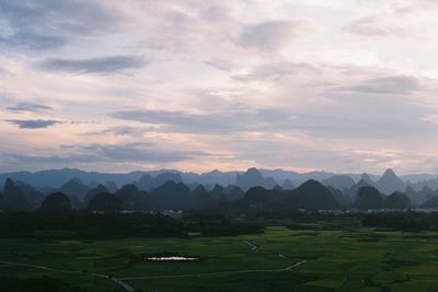 Scenic view of agricultural field against sky during sunset