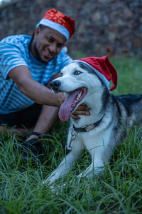 Man with his pet with christmas hats.