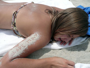 Close-up of young woman lying on sand