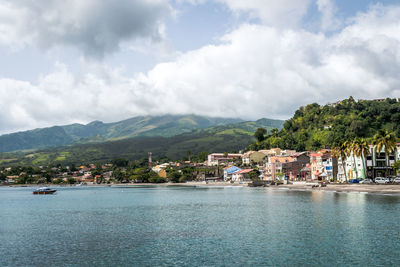 Scenic view of sea by buildings against sky