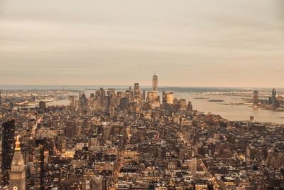 High angle view of city buildings against cloudy sky