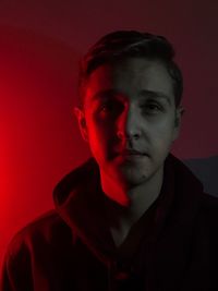 Close-up portrait of young man against red background