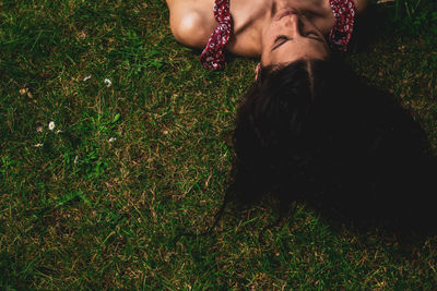 Young woman lying on grass with long straight hair