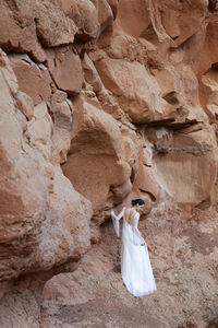 Rear view of woman standing against rock formations
