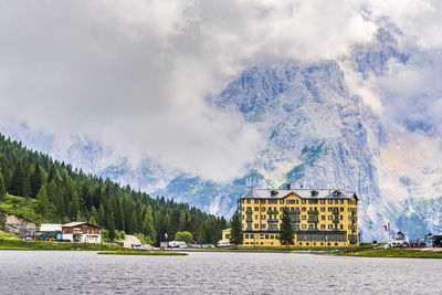 Panoramic shot of buildings by lake against sky