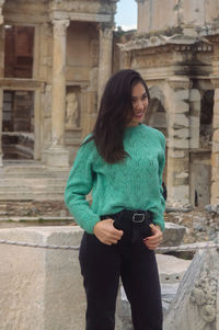 Young woman standing against historic building