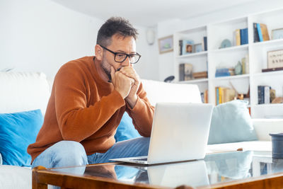 Young woman using laptop while sitting at home