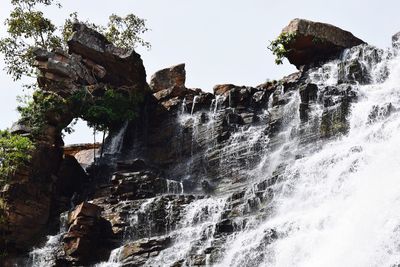 Low angle view of waterfall against sky