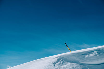 Low angle view of snow against blue sky