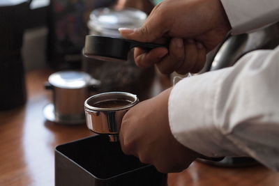 Cropped image of barista making coffee in cafe